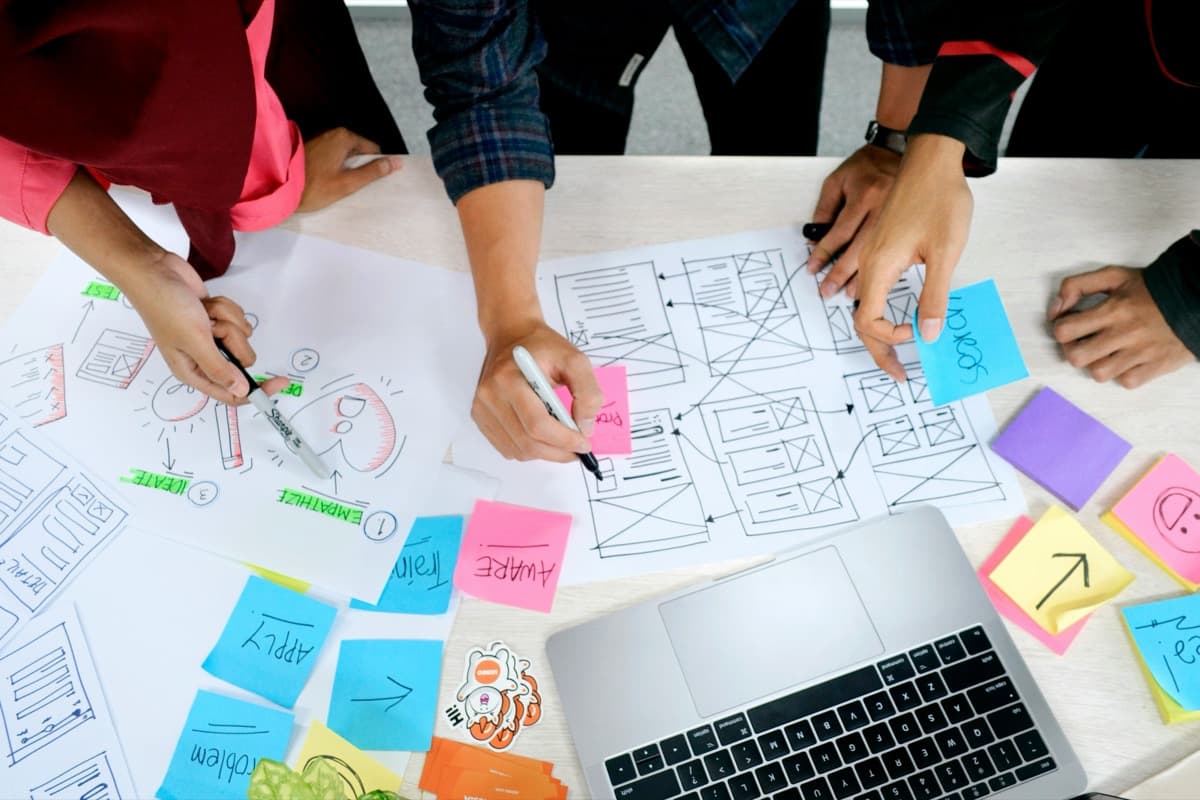 Team sketching interface wireframes on paper