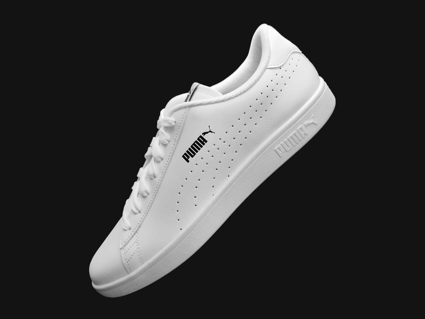 White Puma sneaker photographed on a dark studio background